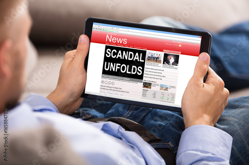 Man Reading Unfolds Scandal News On Digital Tablet