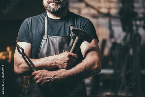 Senior blacksmith in smithy.