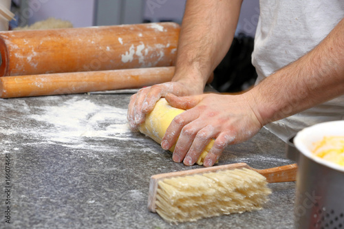 Baker kneading dough for cake in a bakery