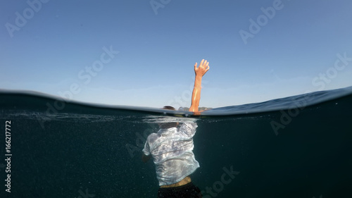 young man sinking into the sea