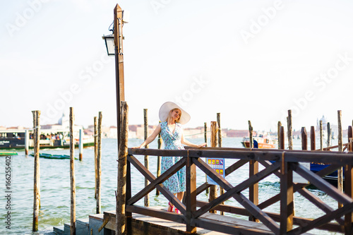 Travel tourist woman with backpack in Venice, Italy. girl on vacation smiling happy by Grand Canal. girl having fun traveling outdoors.