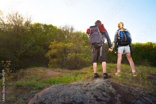 Man and woman traveler outdoors.Couple of Hikers holding their 