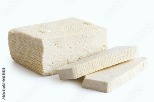 Block of white tofu and two slices isolated on white.