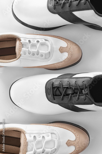 Two pairs of leather golf shoes on white background