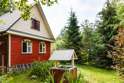 view of cottage and well from backyard in village