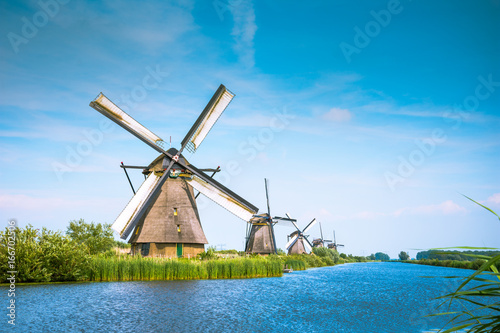 Traditional village with dutch windmills and river at sunset, Holland, Netherlands.