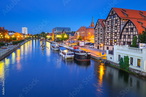 Architecture of Bydgoszcz city with reflection in Brda river at night, Poland