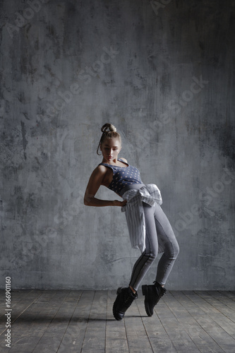 Young beautiful dancer is posing in studio