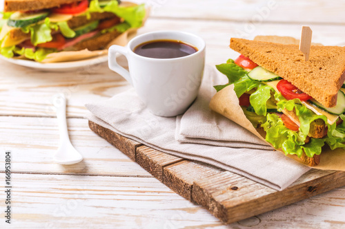 Rye bread sandwich with ham, cheese, lettuce and coffee