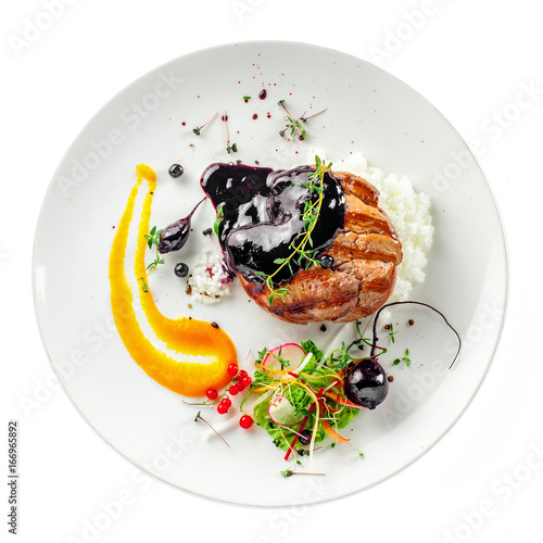 Gourmet meat steak, vegetable salad, sauce and rice on a plate. Delicious healthy meal made of grilled meat and vegetables isolated on white background.