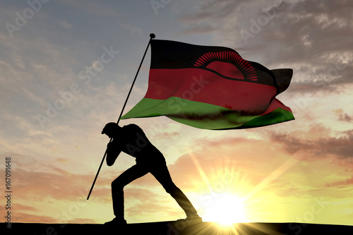 Malawi flag being pushed into the ground by a male silhouette. 3D Rendering
