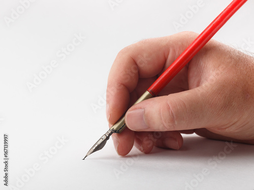 hand holding old inkpen on white paper background