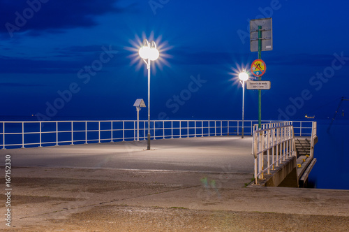 Small pier in Gdynia at Feliks Nowowiejski boulevard on Baltic sea at night.