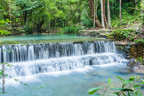 Jungle stream flowing into a small pool, with surrounding rain forest at Paeng Waterfall, Ko Pha Ngan, Thailand.