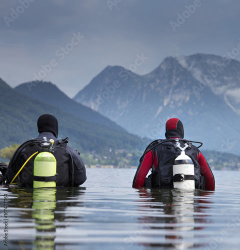 Divers entering water in mountain lake