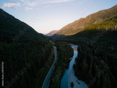 Aerial shot of road in valley while sunset behind mountain