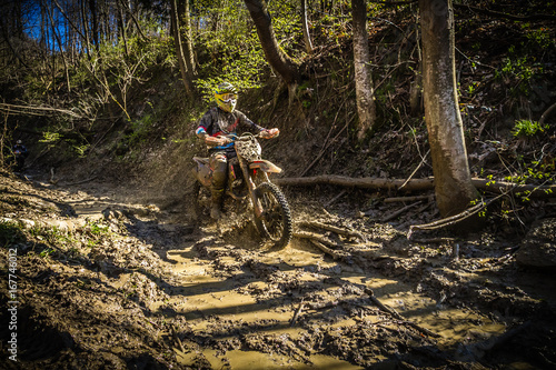 Motocross rider passes through the mud on the hardenduro race