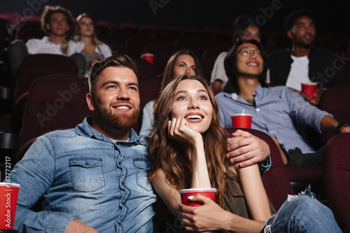 Happy young couple sitting at the cinema
