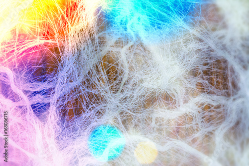 Abstract showy colorful glows. White tangled fibers on brown background. Artistic vivid cheerful texture with atmosphere of celebration or party. Playful colored light. Diffraction and dynamic effect.