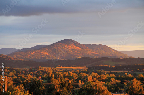 landscape of Beskydy mountains in the evening light with blue clouds above the hills