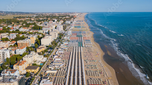 Drone aerial view of the umbrellas and gazebos on Italian sandy beaches. Adriatic coast. Emilia Romagna region