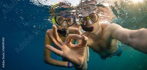 Young couple enjoying snorkeling underwater. Selfie portrait