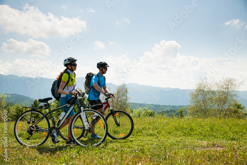 AKTYWNE Młoda para na rowerze po leśnej drodze w górach w wiosenny dzień