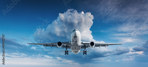 Beautiful airplane. Landscape with white passenger airplane is flying in the blue sky with clouds at overcast day. Travel background. Passenger airliner. Business trip. Commercial plane. Aircraft