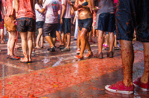 Tłum ludzi bawiących się na La Tomatina. Ujęcie nóg. 