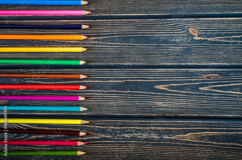 colored pencils on wooden background