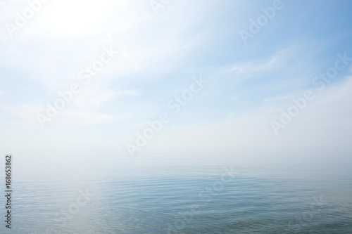 Calm tranquil blue sea with no waves and with foggy backgroudn