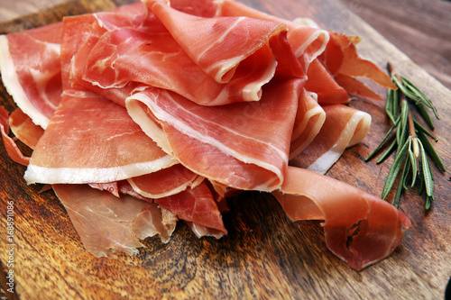 Italian prosciutto crudo or jamon with rosemary. Raw ham.