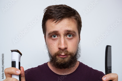 Young bearded man ready to trim, comb and sort out his long messy beard