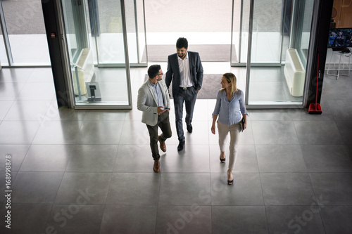 Business team gets to work. Three people entering the building.