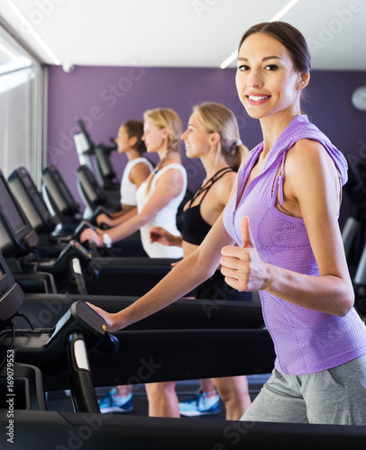 Satisfied girls running on treadmills