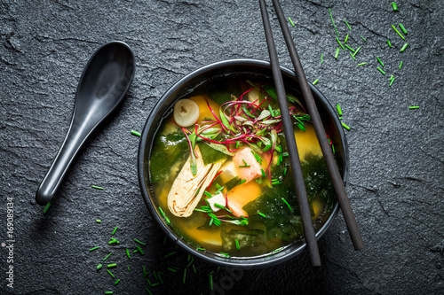 Hot and tasty miso soup with salmon on black rock