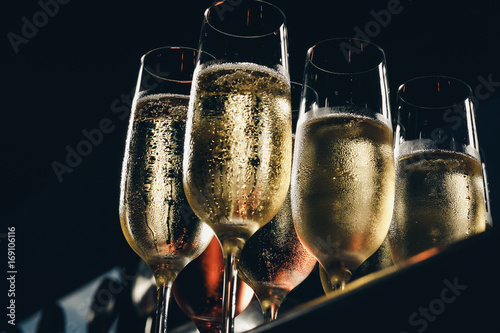 a row of glasses filled with champagne are lined up ready to be served