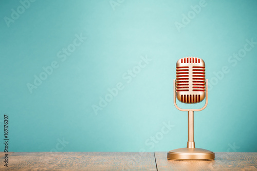 Golden retro old microphone for press conference or interview on table. Vintage style filtered photo