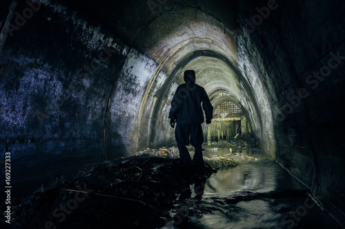 Sinker tunnel worker in protective suite in underground gassy sewer tunnel