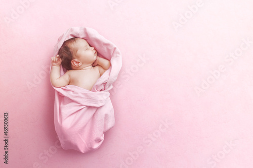 Newborn baby girl sleep on pink blanke