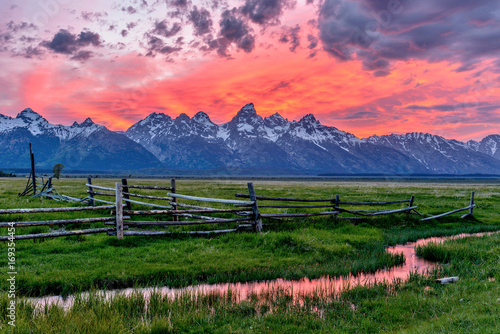 Sunset at Grand Teton - A panoramic view of a spectacular spring sunset at Teton Range, seen from an abandoned old ranch in Mormon Row historic district, in Grand Teton National Park, Wyoming, USA. 