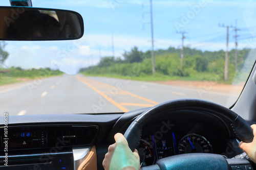 Hands driving in highway.