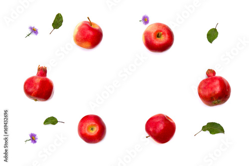 Red apples, garnets and violet flowers on a white background. Top view, flat lay