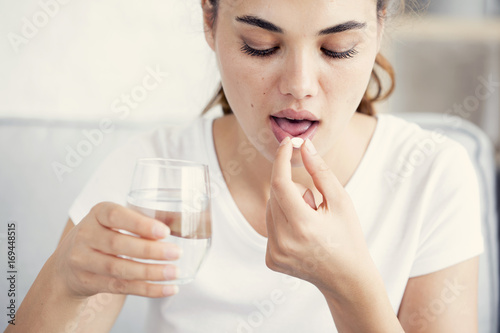 Young woman taking pill