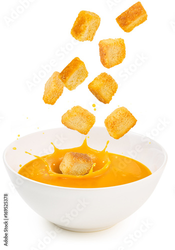 croutons falling into a soup bowl isolated on white