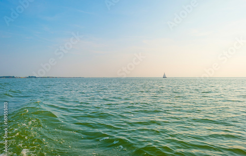 Sailing boat sailing on a lake at sunset in summer