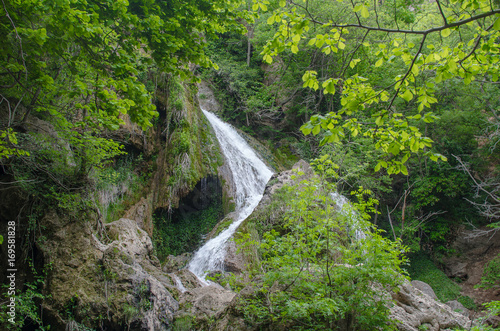 A small waterfall in the forest, flows from the mountains.