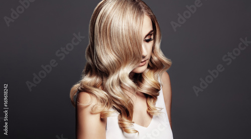 Elegant woman with shiny wavy blond hair