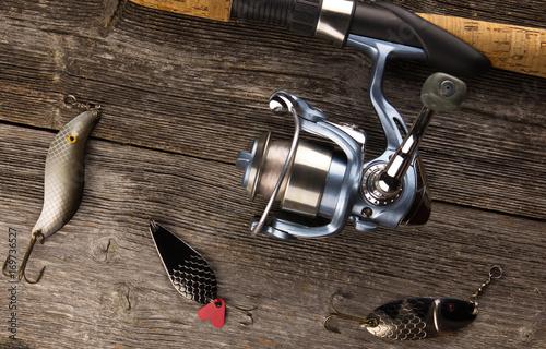 spinning rod And bait on a wooden background