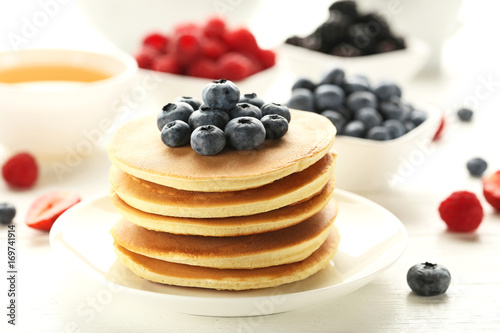 Tasty pancakes with blueberries on white wooden table